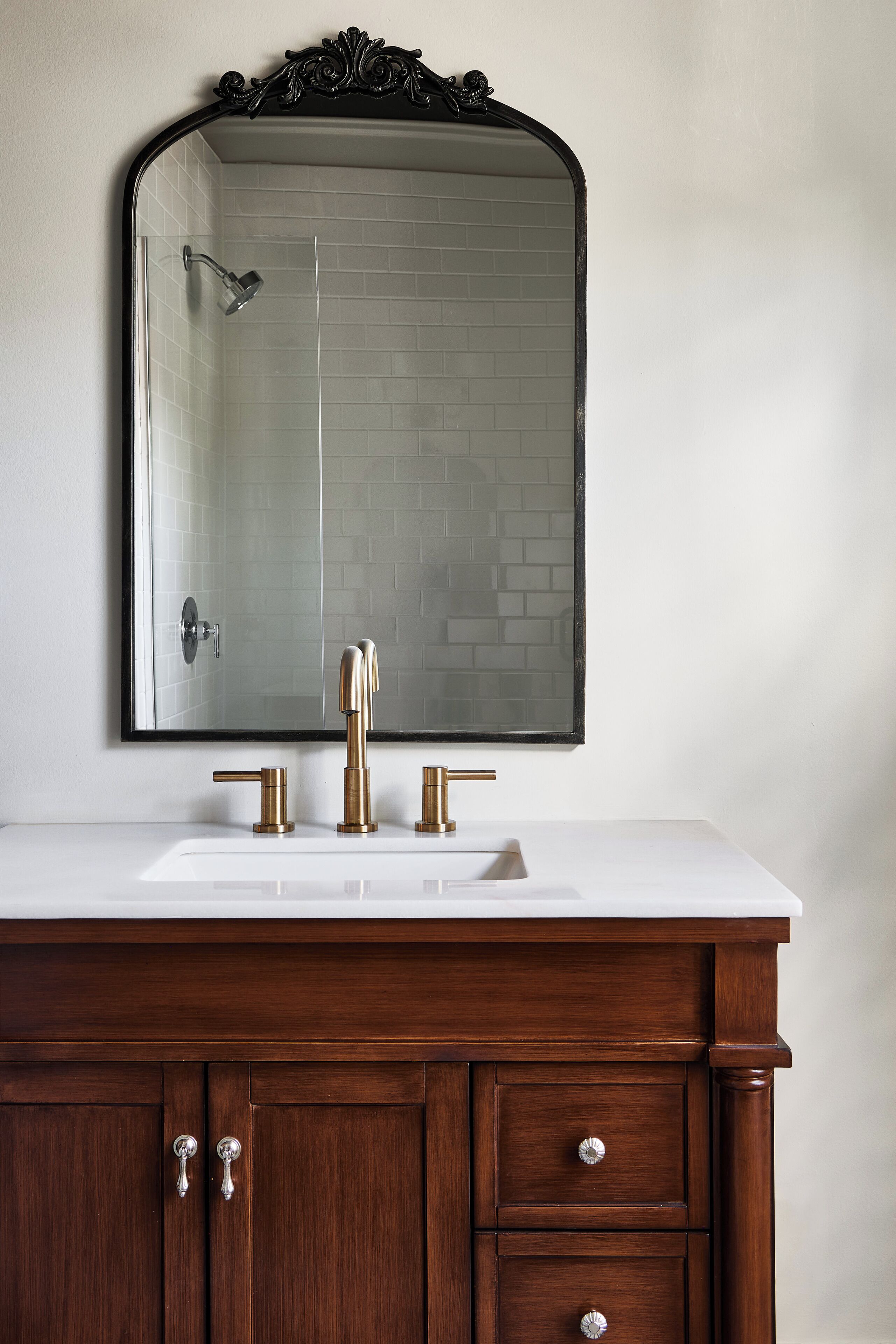 A bathroom with a white sink, a large mirror, and a shower.