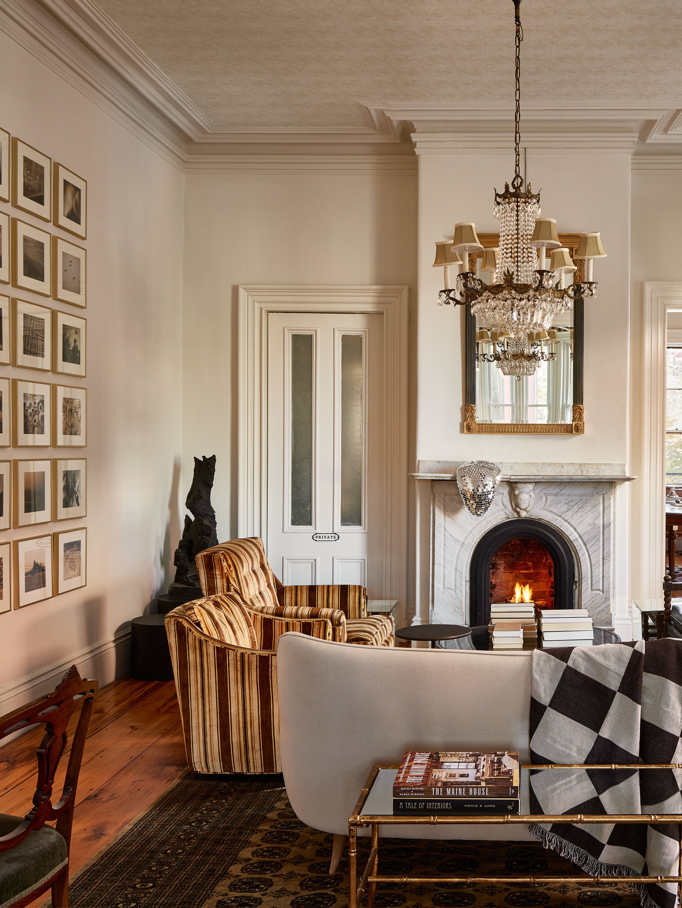 A living room with a fireplace, a chandelier, and a sofa.