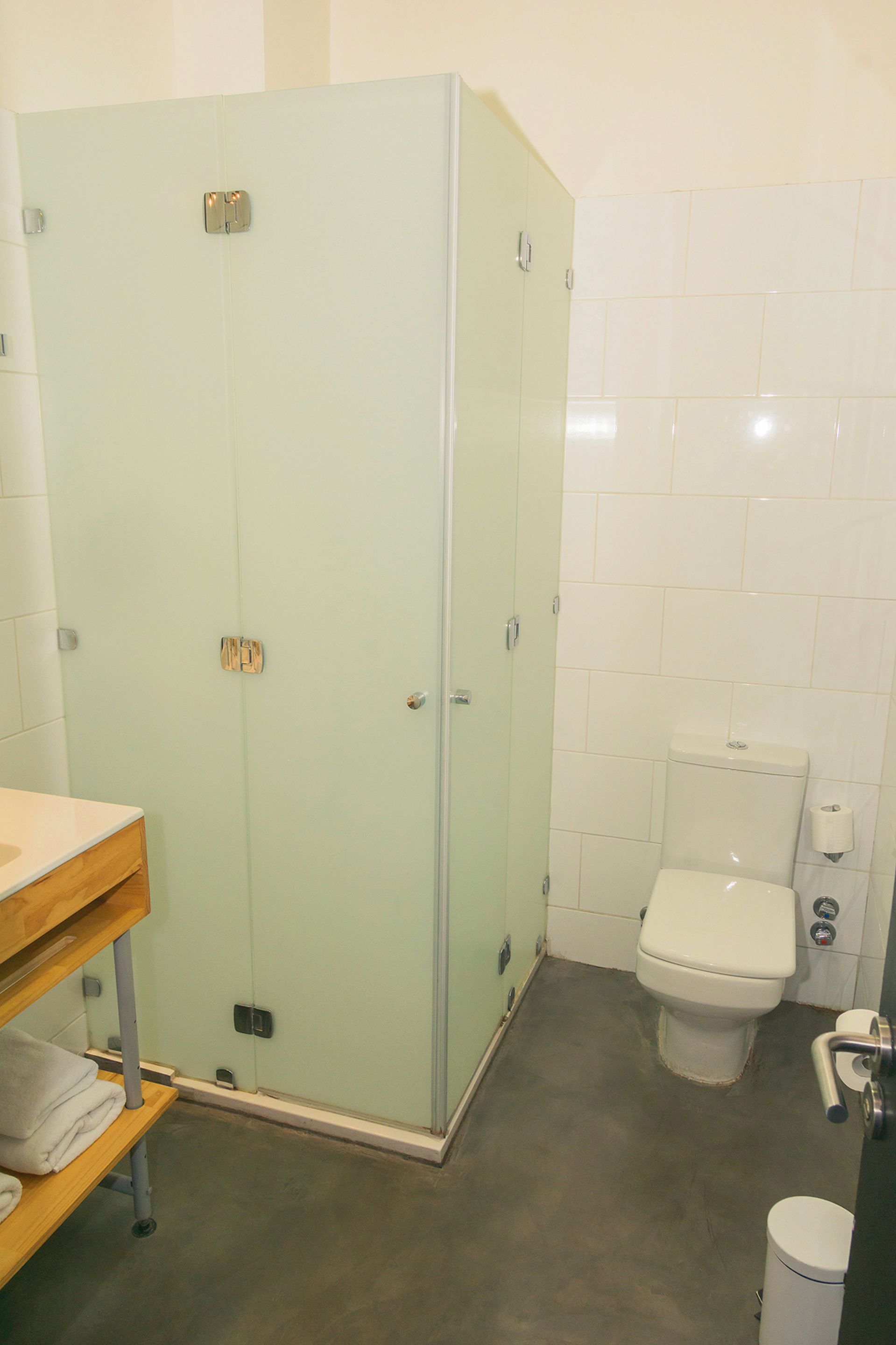 A bathroom with a toilet, a sink, and a cabinet.