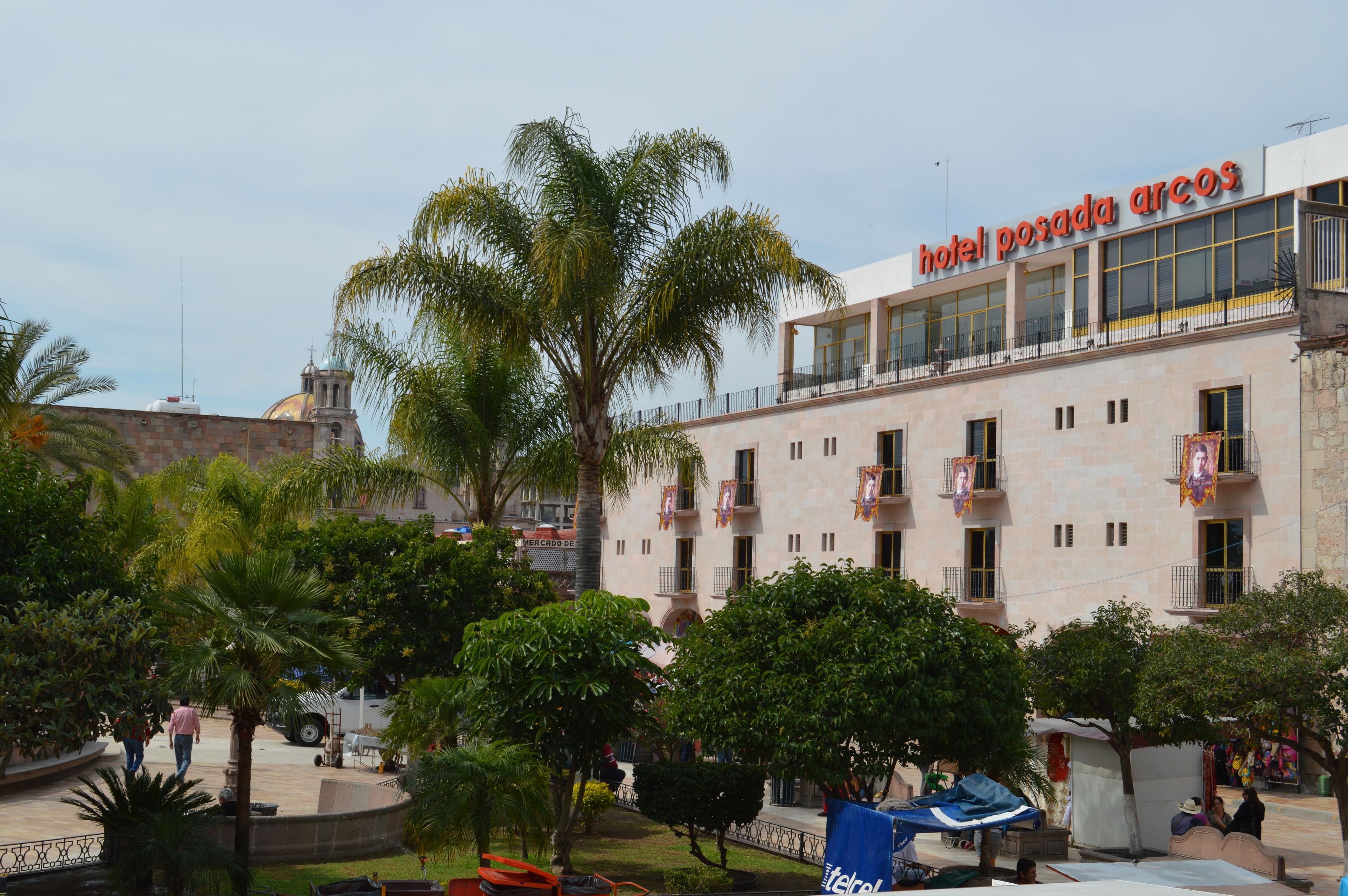 A hotel with a modern facade, multiple balconies, and a prominent sign.