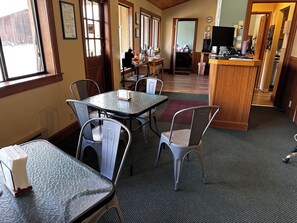 A restaurant with a bar area, tables, and chairs.