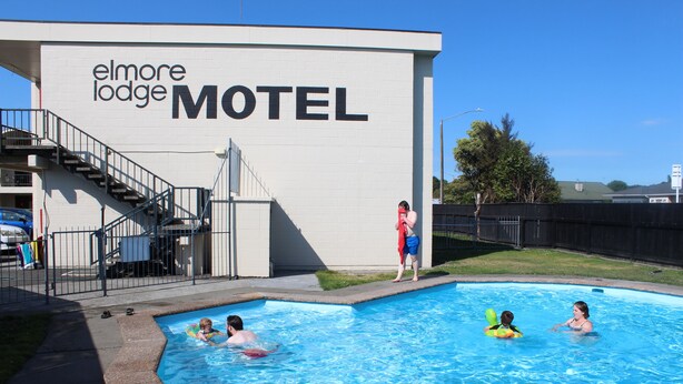 A swimming pool area at the Elmore Lodge Motel with a visible staircase leading to the motel's entrance. - Elmore Lodge Motel (Hastings)