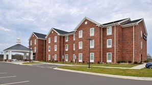 A multi-story brick building with a covered entrance and a parking lot in front. - Appomattox Inn and Suites (Appomattox)