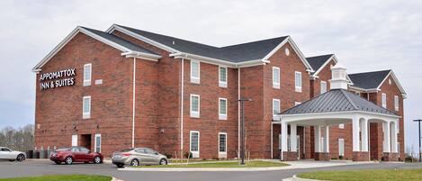 Un edificio de ladrillo con un letrero que dice "Appomattox Inn & Suites".