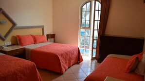 Habitación de hotel con dos camas, un ventanal grande y vistas al exterior.
