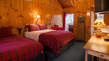 A cabin with two beds, a dining table, and a window with a view.