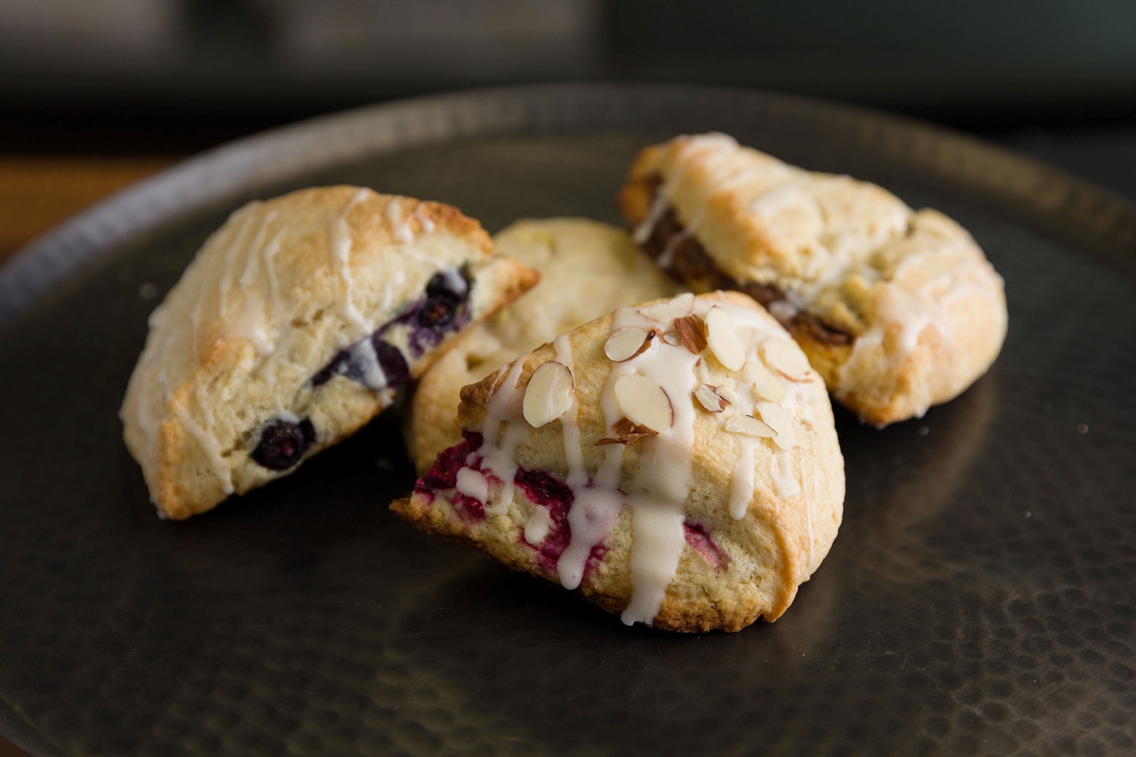 Three pastries on a dark plate.