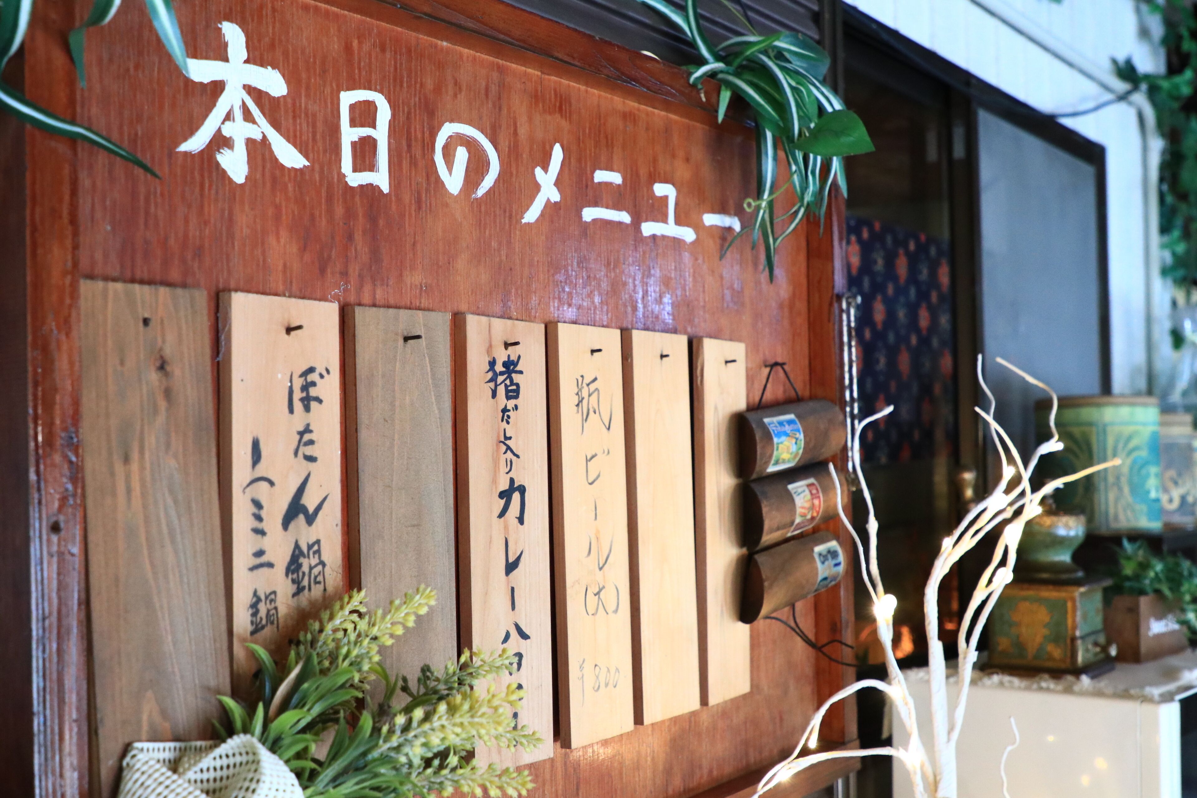 Een houten bord met Japanse tekens en verschillende houten plaquettes met handgeschreven tekst.