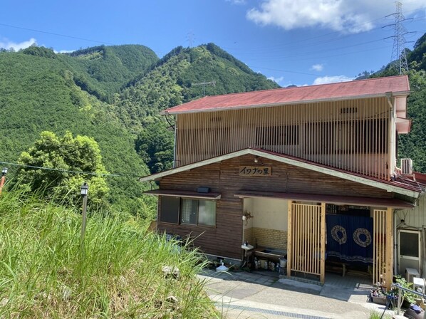 A two-story wooden building with a sign reading "Iwakura's".