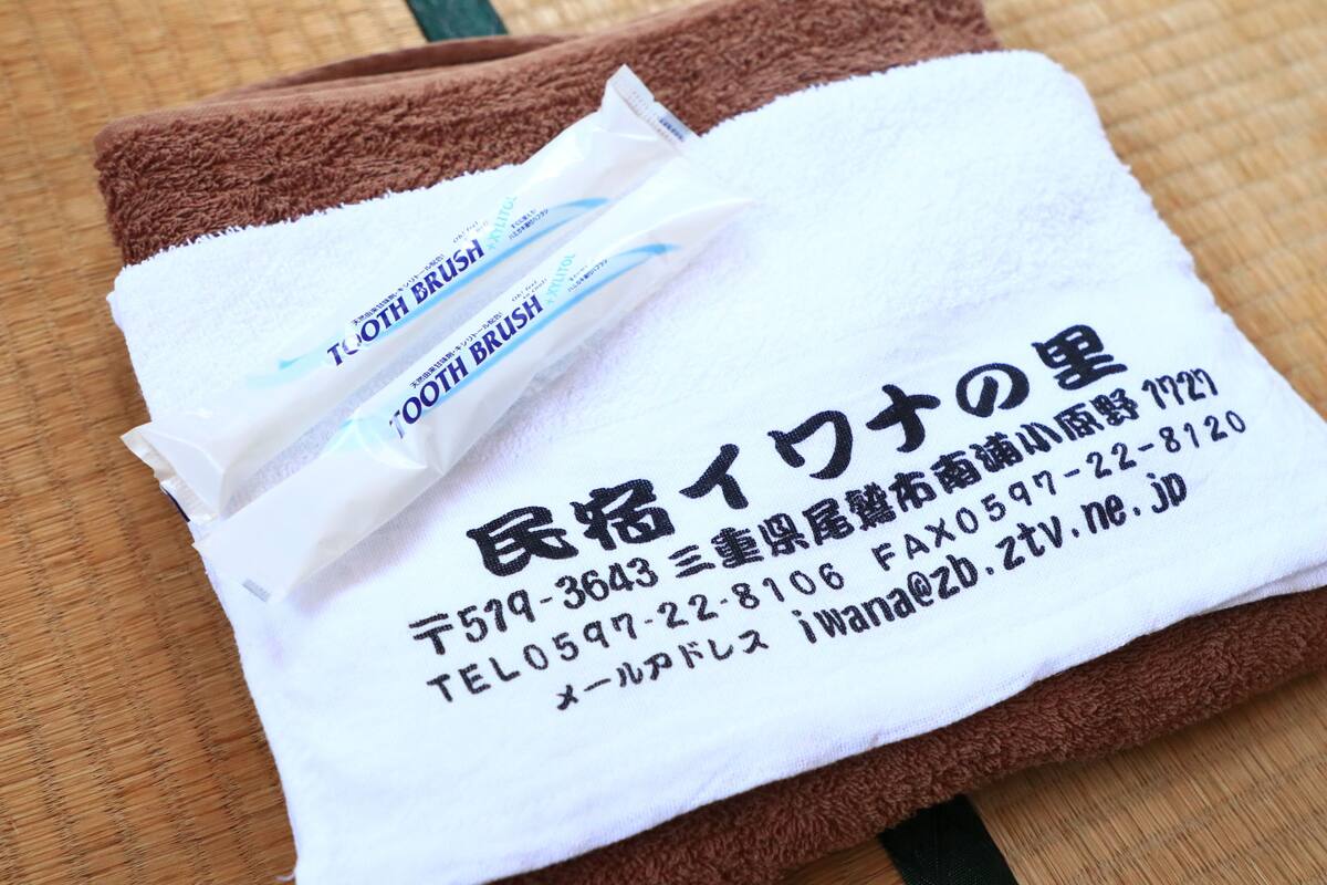 Een witte handdoek met Japanse tekst en een tandenborstel.