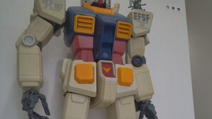 Una gran figura de robot de color beige montada en una pared.