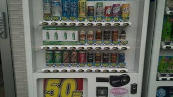 En automater med forskellige drikkevarer og et tydeligt skilt, der viser 50 yen rabat.