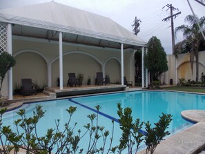 Una piscina al aire libre, tumbonas