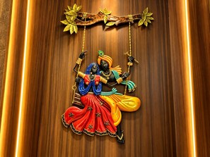Pared de madera con un adorno colgante que muestra una figura con vestimenta tradicional.