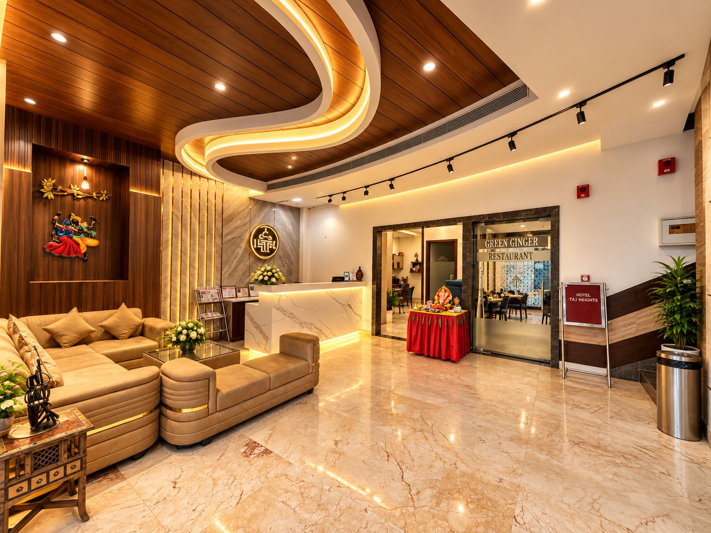 A hotel lobby with a reception desk, a sofa, a dining area, and a staircase.