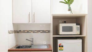 A compact kitchen with a sink, a microwave, and a refrigerator. - Motel Myall (Dalby)