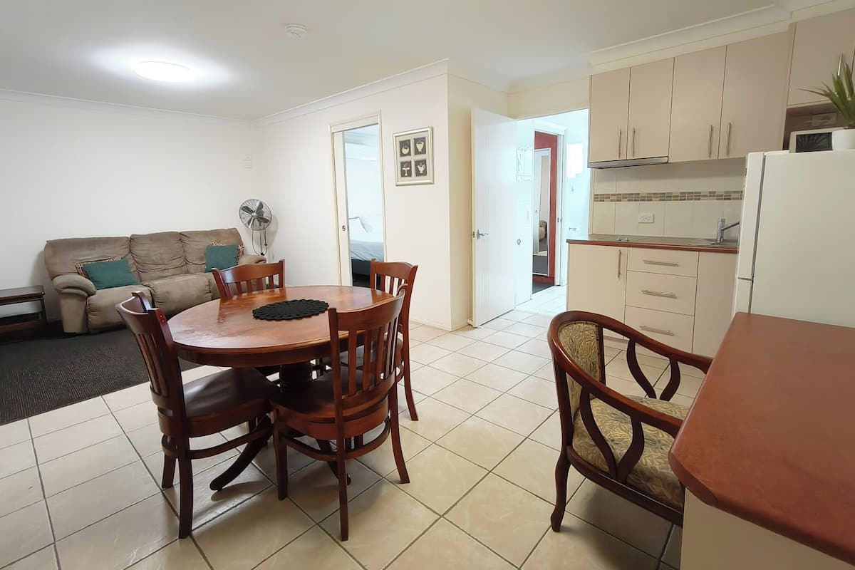 A compact living space with a dining area, kitchenette, and a sofa.
