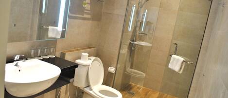 Une salle de bain moderne avec une douche à parois de verre, un lavabo blanc et des toilettes.