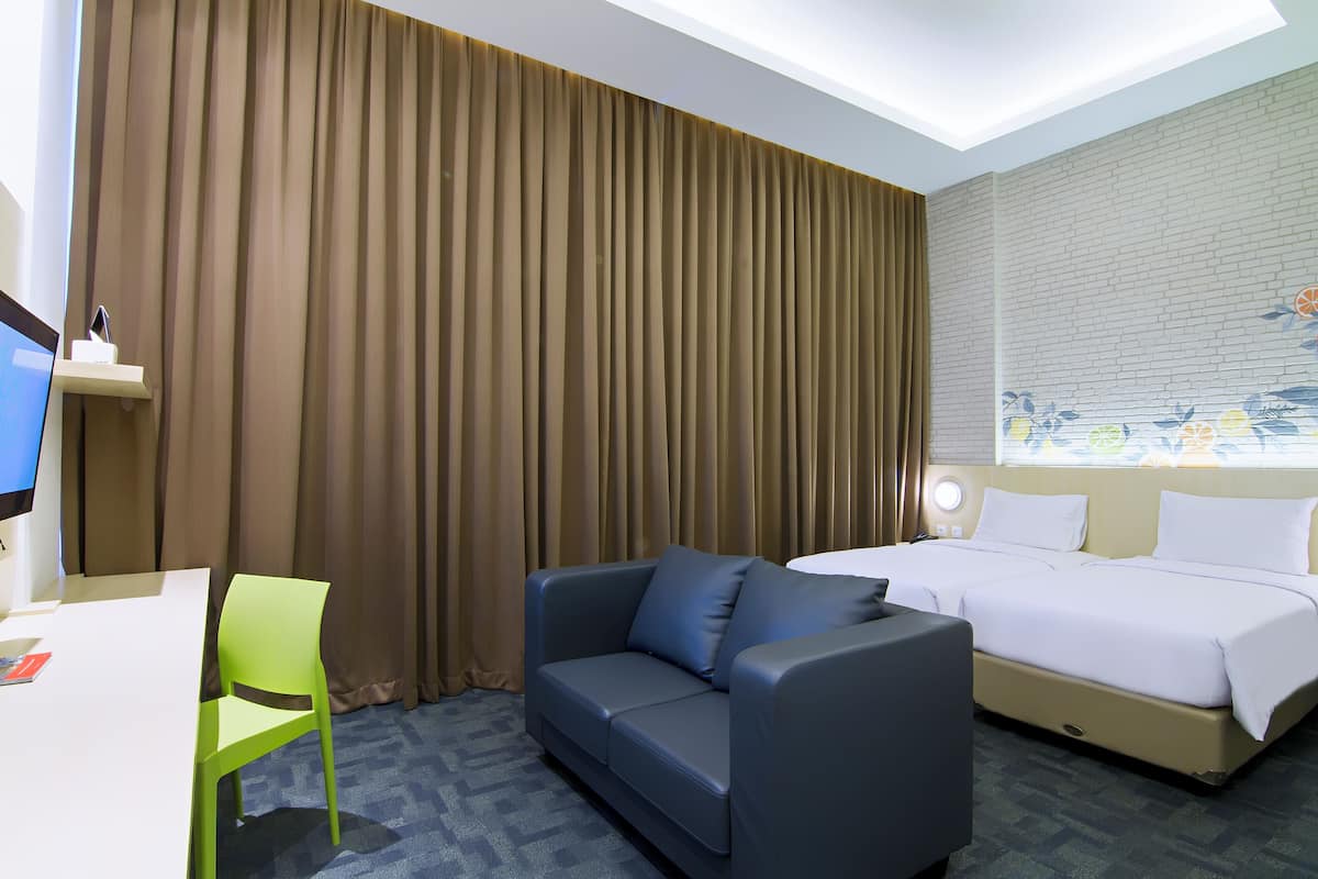Une chambre d’hôtel avec un lit, un canapé, un bureau et une chaise.