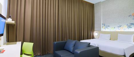 A hotel room with a bed, a sofa, a desk, and a chair.