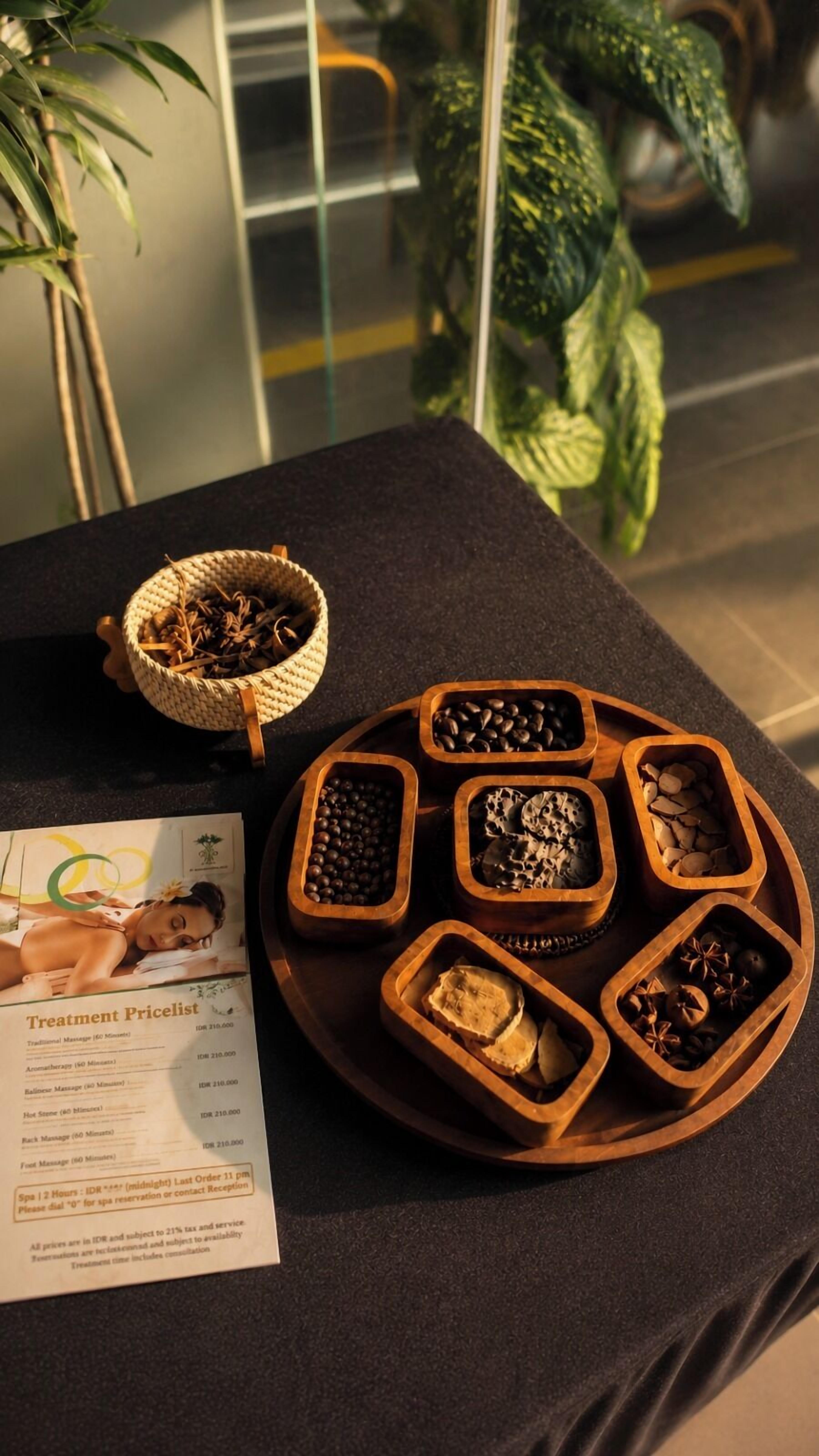 Une table sur laquelle se trouvent une brochure, un plateau contenant divers objets dans des récipients en bois, et un panier tressé.