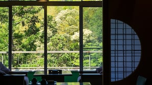 Habitación con amplios ventanales que ofrecen vistas a un área boscosa.