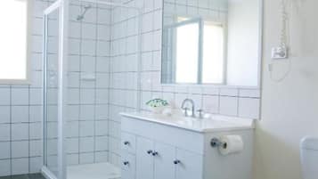 A bathroom with a shower, toilet, and sink.