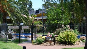 Zona de piscina vallada con un cartel que indica que no se permiten vasos ni botellas de vidrio.