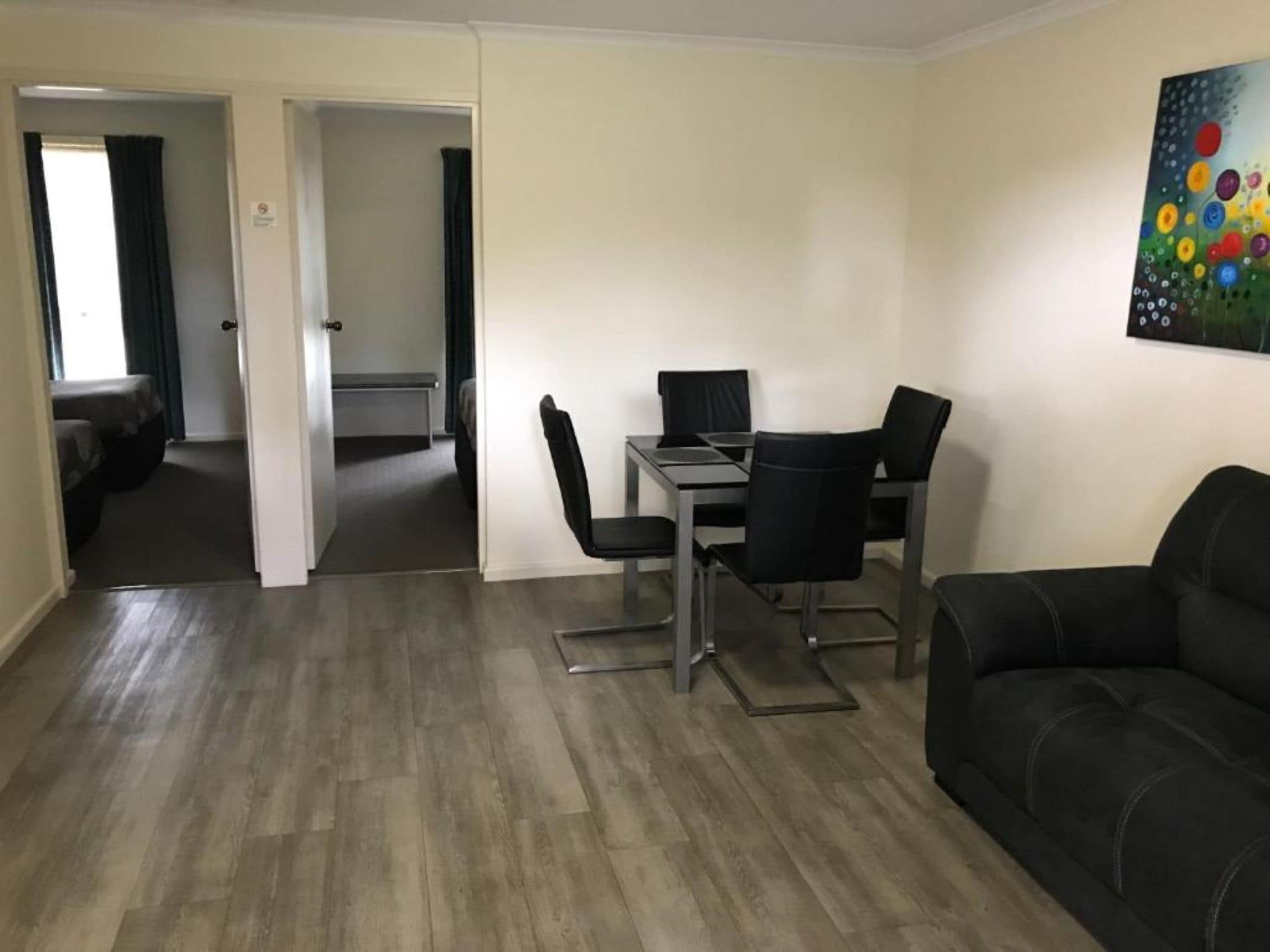 Un espacio habitable compacto con comedor, sofá y un cuadro en la pared.