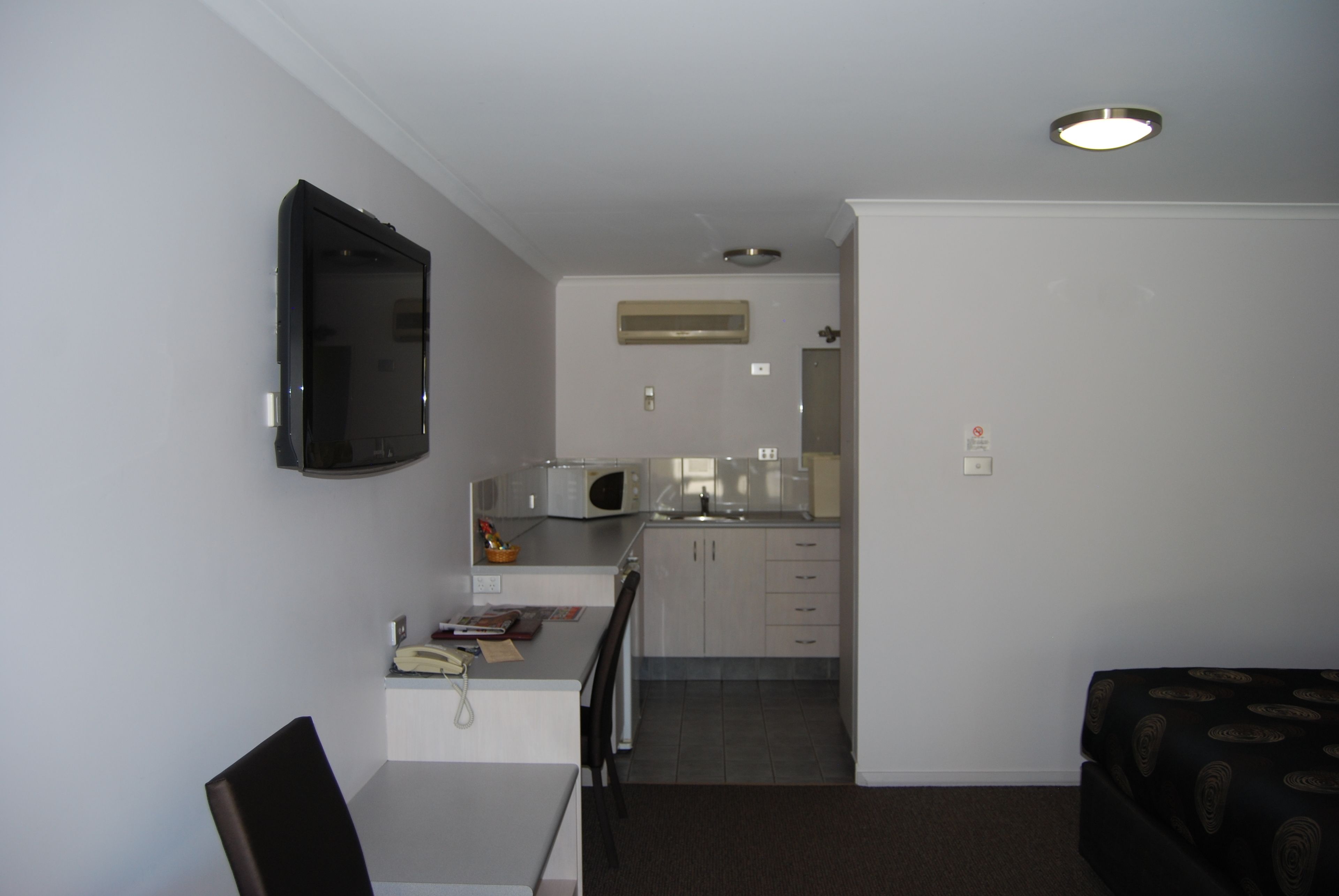 A compact living space with a kitchenette, a dining area, and a seating area.