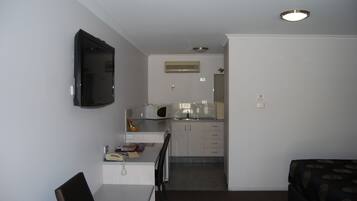 A compact living space with a kitchenette, a dining area, and a seating area.