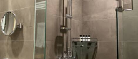Un bagno moderno con box doccia in vetro, lavandino bianco e porta asciugamani.