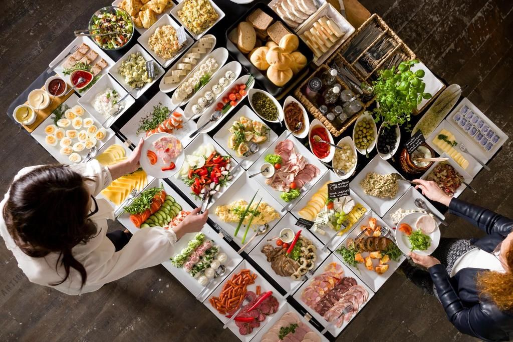 Vista cenital de un bufé con diferentes alimentos y condimentos.