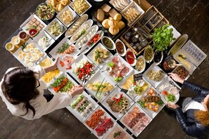 Vista cenital de un bufé con diferentes alimentos y condimentos.