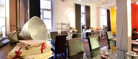 A hotel lobby with a glass table displaying teacups, a stack of papers, and a metal pot.
