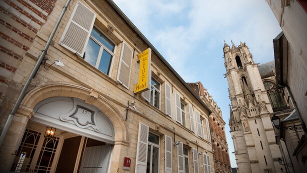 A hotel with a yellow sign, a bell tower, and a stone facade. - Hôtel le Prieuré (Amiens)