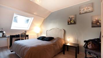 Ein Schlafzimmer mit Bett, Schreibtisch, Stuhl, Lampe und Fenster.