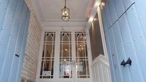 A staircase leading to a door with a light fixture above. - Hôtel le Prieuré (Amiens)