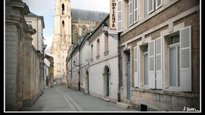 A narrow street with historic buildings, a church tower, and a hotel sign. - La Résidence le Prieuré (Amiens)