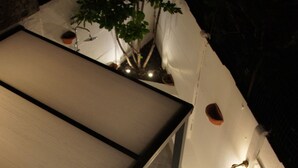 A tiled floor with a bench and a wall-mounted light fixture. - J and R Brussels City Apartment (Brussels)