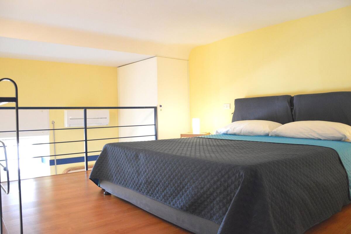 Ein Schlafzimmer mit Bett, Fenster und Tür.