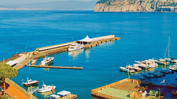 A coastal marina with boats docked, a pier extending into the water, and buildings along the shore. - Sorrento Guest House (Sorrento)