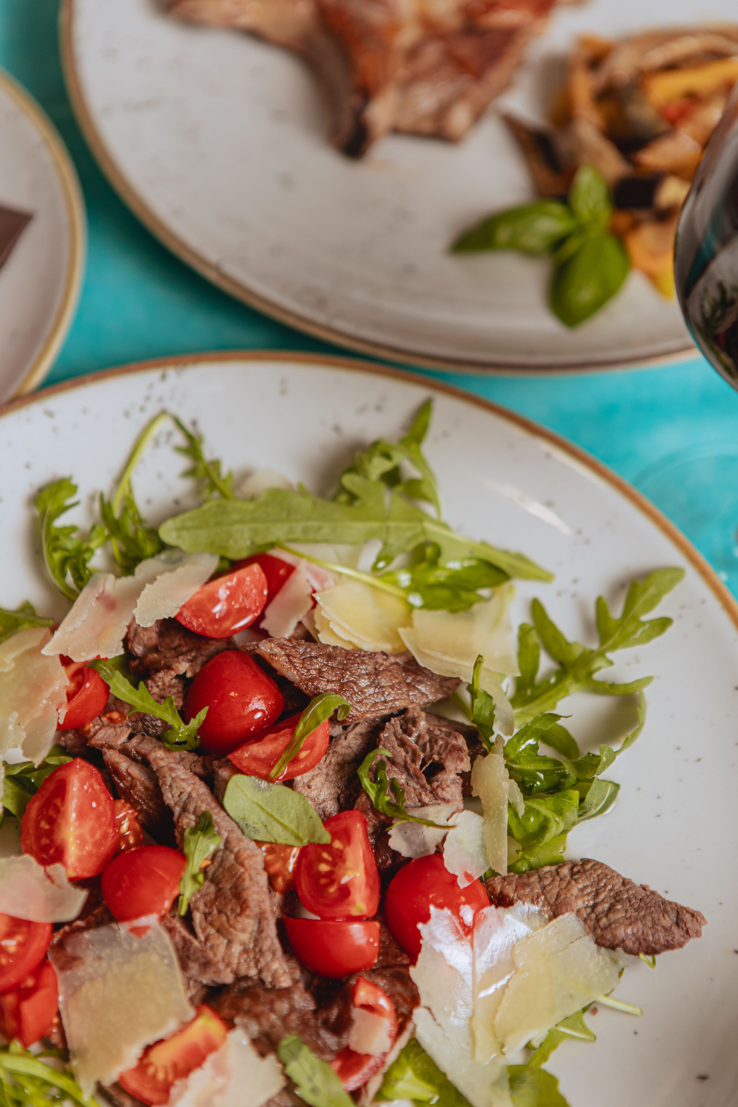 A plate of beef salad with tomatoes and cheese.