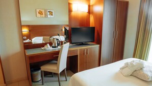 A hotel room with a bed, a desk with a computer, a chair, a television, and a wardrobe. - Hotel Amico (Citta Sant'Angelo)