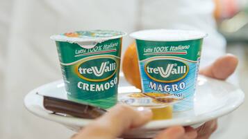 Un plateau contenant deux pots de treValli Magro et Cremoso, que tient une personne.