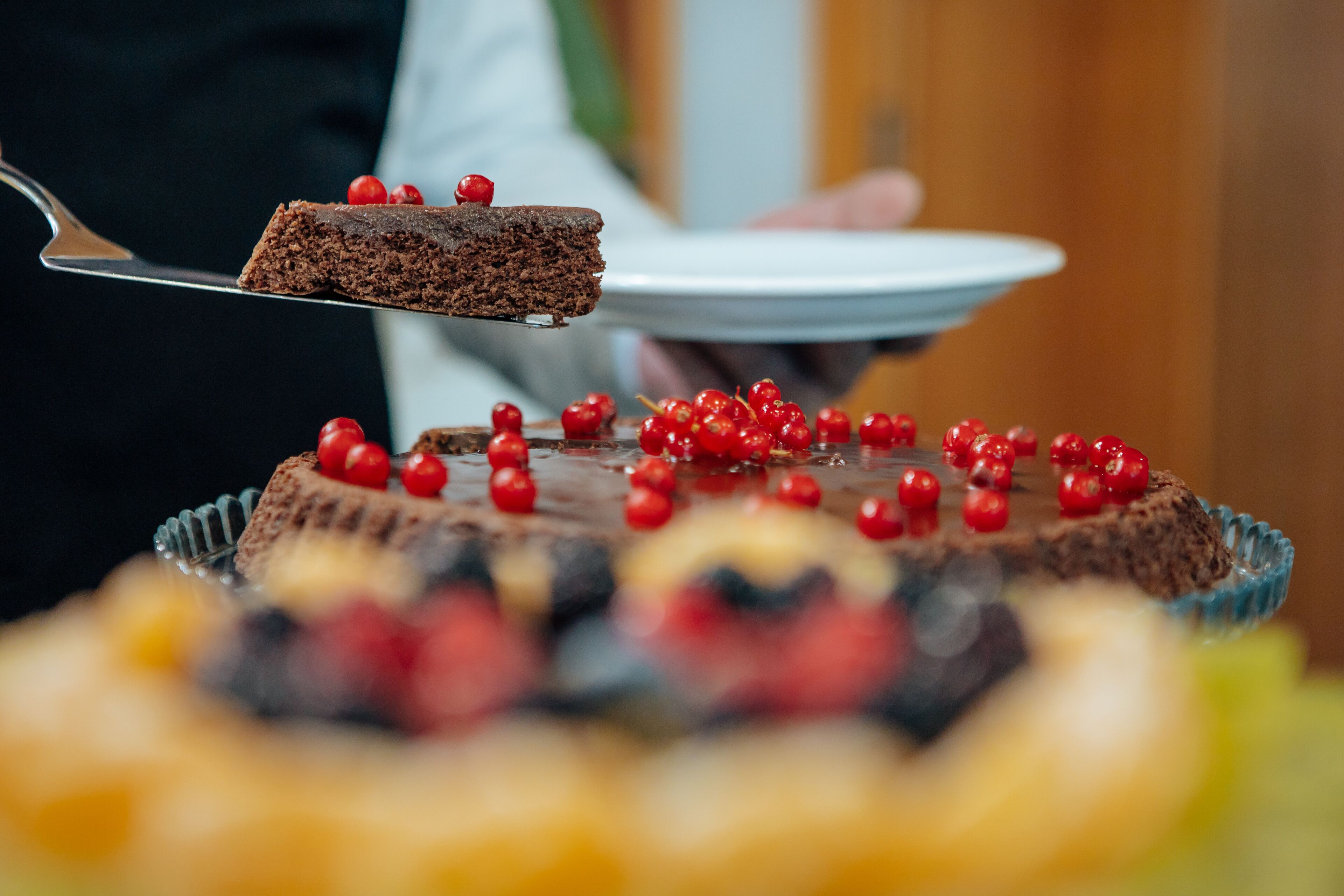 A slice of chocolate cake with berries on a plate.