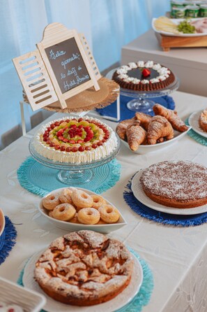 A buffet table with various desserts including cakes, pastries, and fruit arrangements. - Hotel Amico (Citta Sant'Angelo)