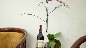 Una mesa con una botella de vino, dos copas y una orquídea.