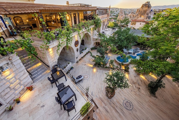 A rooftop terrace with outdoor seating, a swimming pool, and a view of the cityscape. - Kayatas Cave Suites (Nevsehir)