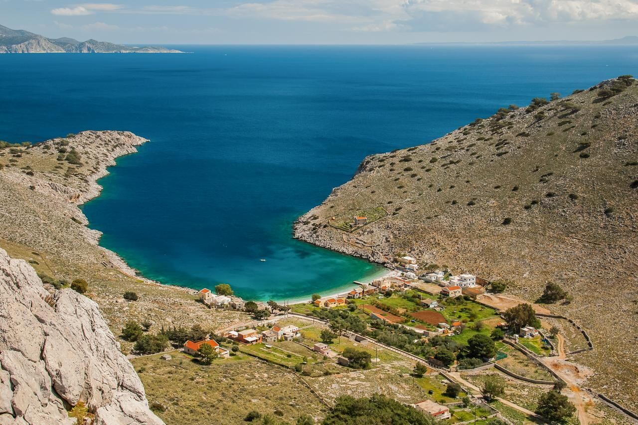A coastal village with rocky terrain and a clear blue sea.